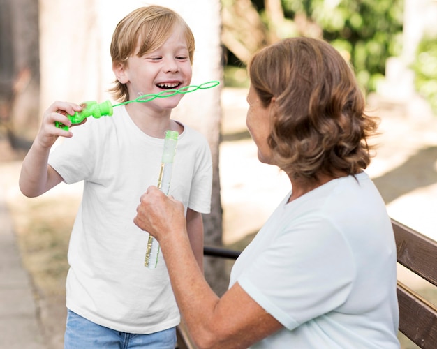 写真 石鹸風船を作るミディアムショットの少年