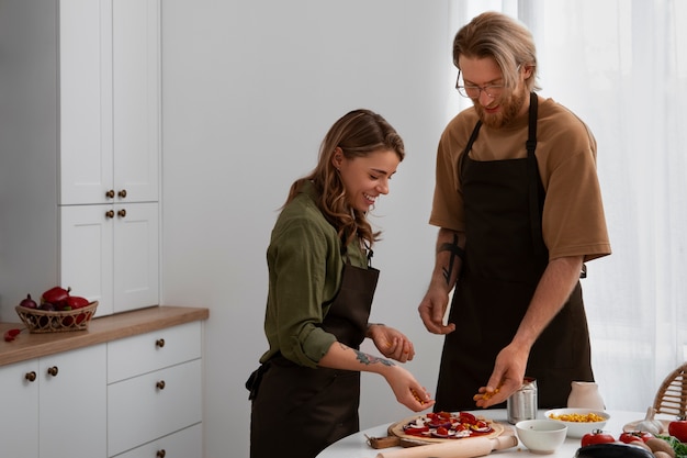 Foto coppie del colpo medio che cucinano insieme