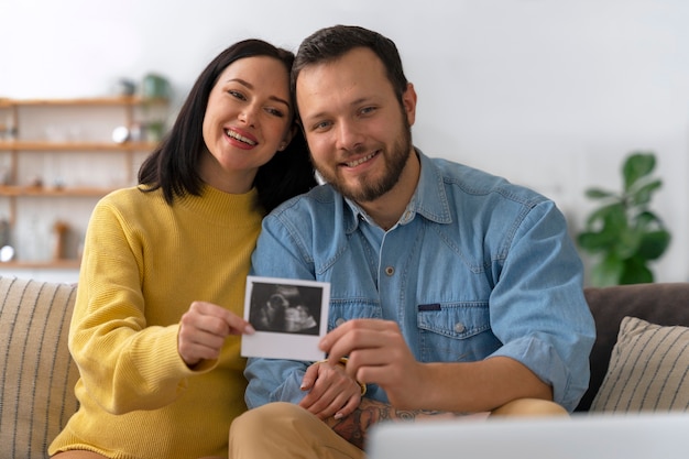 Medium shot couple holding ultrasound