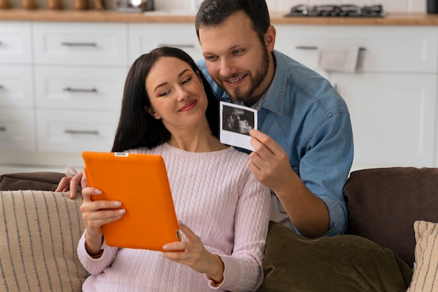 Medium shot couple holding ultrasound