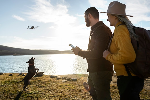 Foto coppia di tiro medio con drone e cane