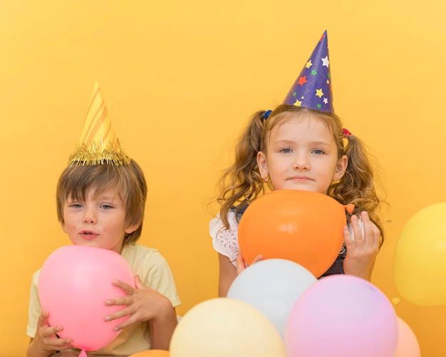 Photo medium shot cute kids holding balloons