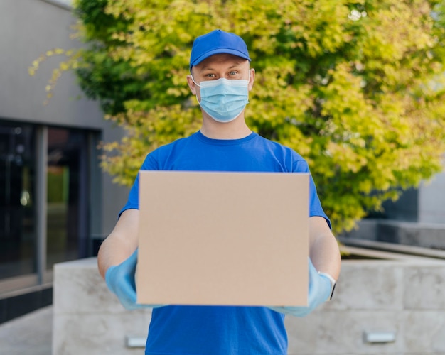 Photo medium shot delivery man holding box