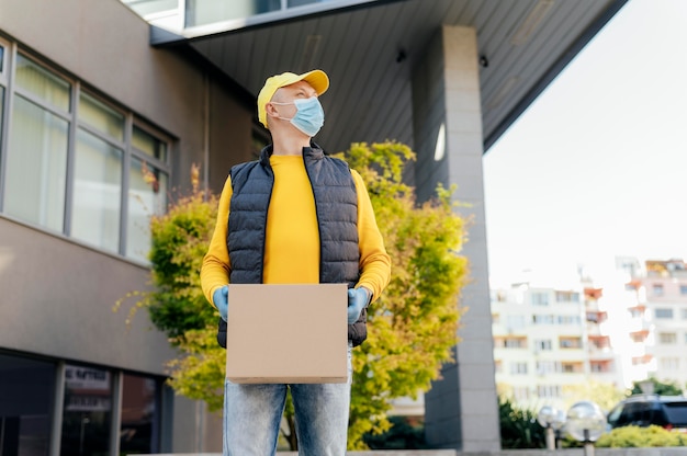 Medium shot delivery man holding box