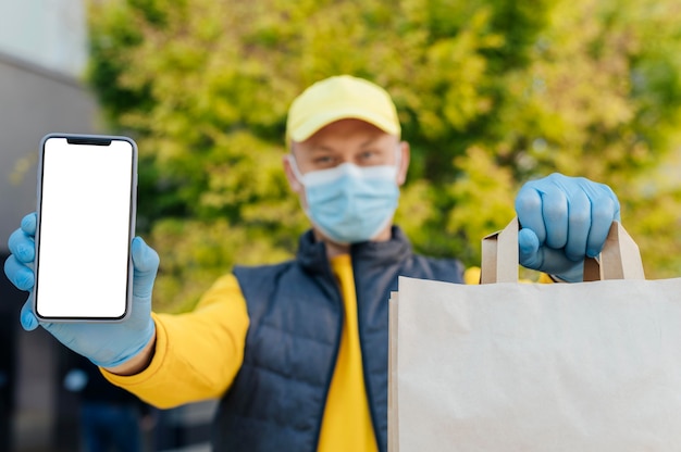 Medium shot delivery man holding phone