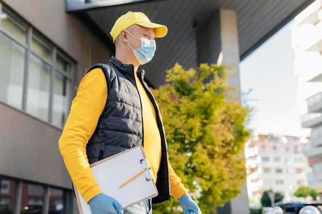 Photo medium shot delivery man wearing mask