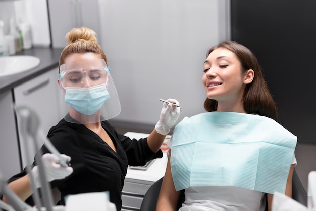 Foto dentista a colpo medio che lavora in clinica