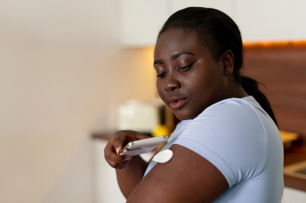 Foto donna diabetica di livello medio che controlla il livello di glucosio