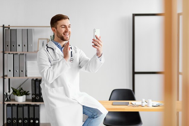 Foto medico del colpo medio che tiene smartphone