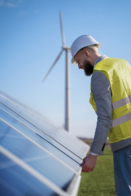 Medium shot environmental engineer checking solar pannels