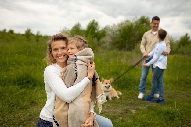 Foto famiglia a tiro medio con cane all'aperto