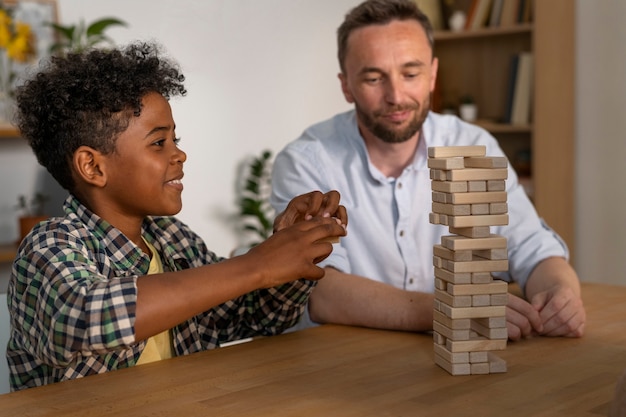 medium shot father and boy playing game
