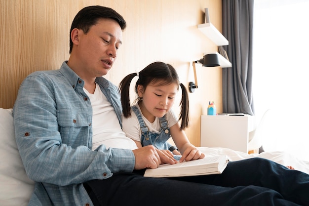 Photo medium shot father and girl reading