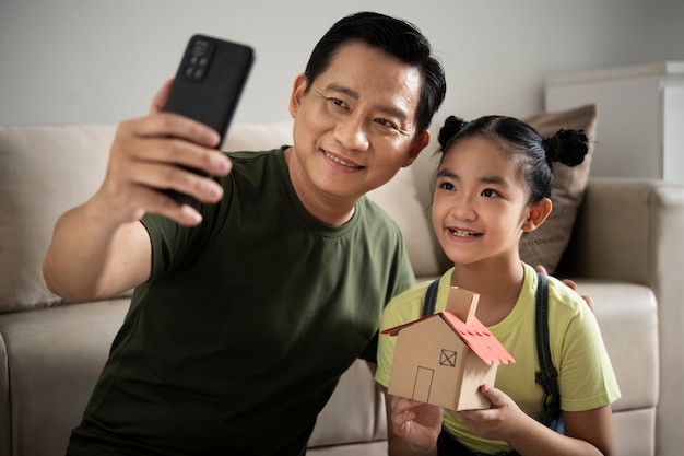 Foto padre e ragazza a tiro medio che si fanno selfie