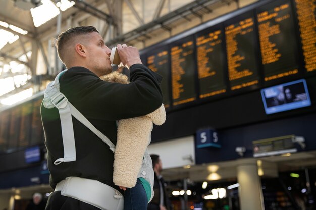 Photo medium shot father holding baby in carrier