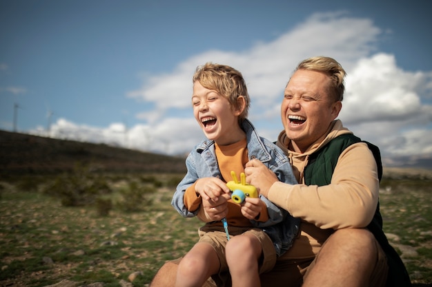 Photo medium shot father holding kid in american desert