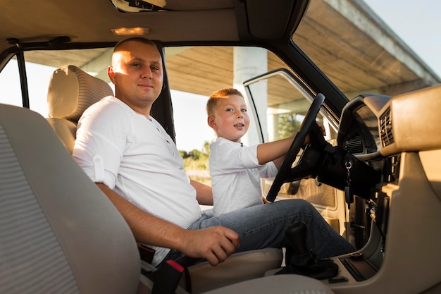 Photo medium shot father and kid in car