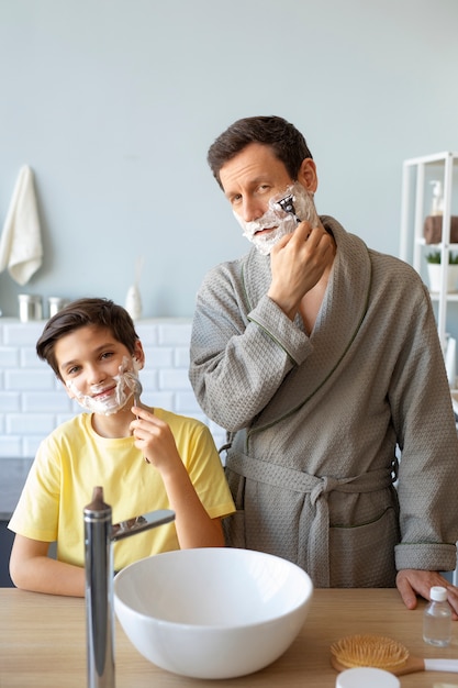 Medium shot father and kid shaving
