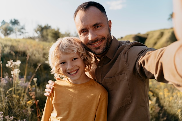 Foto padre e figlio a tiro medio che si fanno selfie