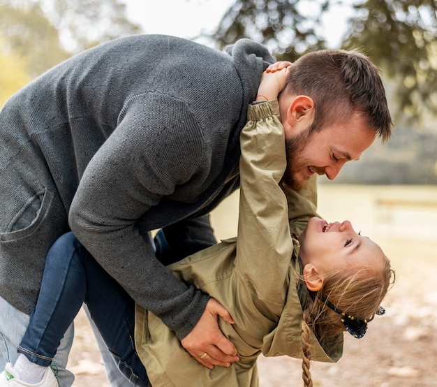 medium shot father playing with daughter