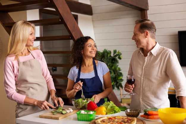 Medium shot friends cooking together