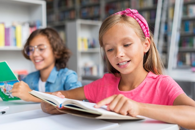 Amici di tiro medio che fanno i compiti insieme in biblioteca