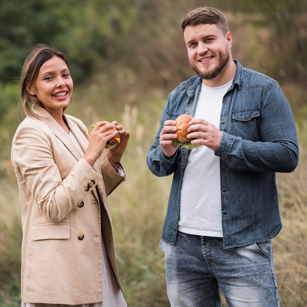 Photo medium shot friends posing with burgers