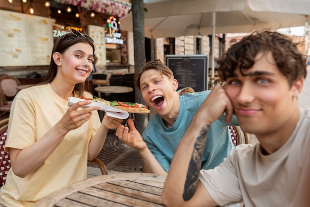 写真 食べ物でポーズをとるミディアムショットの友達