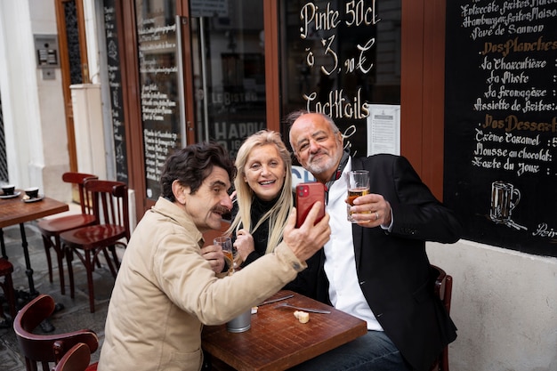 Medium shot friends taking selfie with smartphone