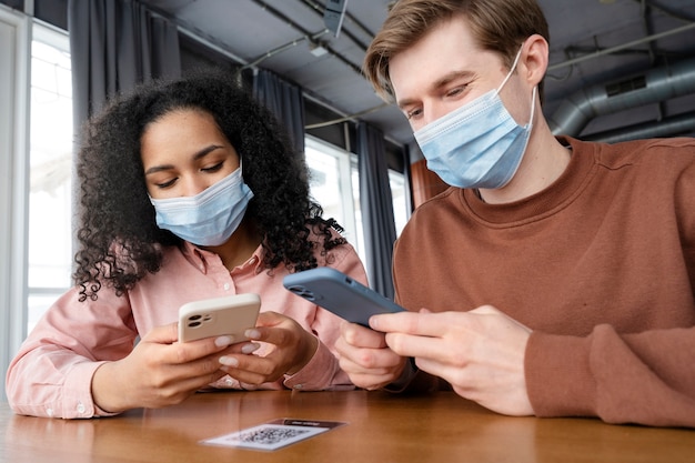 Photo medium shot friends wearing face masks