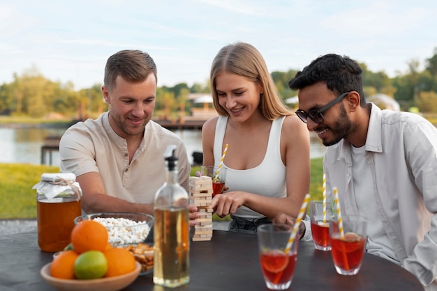 Foto amici di tiro medio con delizioso kombucha all'aperto