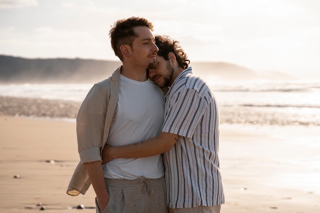 Foto coppia gay di tiro medio in spiaggia