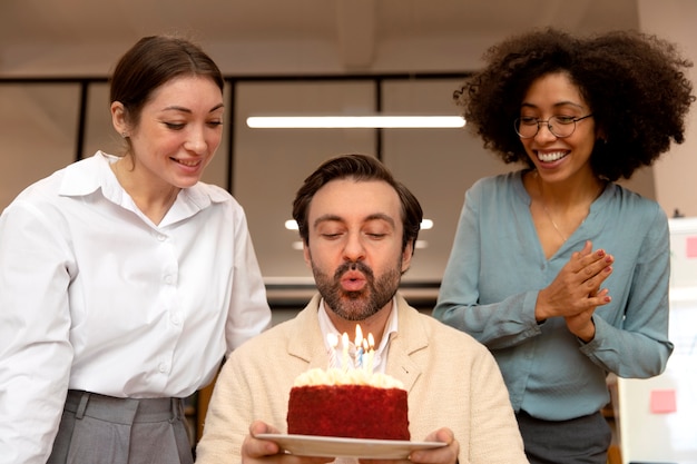 Medium shot gelukkige collega's vieren met cake