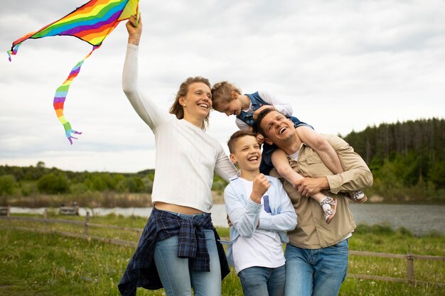 Foto medium shot gelukkige familie met kleurrijke vlieger