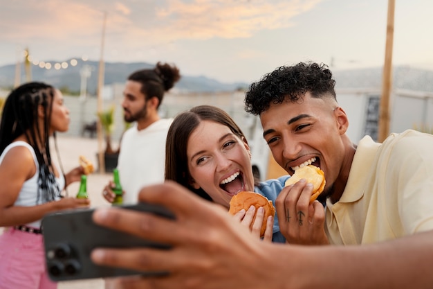 Foto medium shot gelukkige vrienden met eten selfie te nemen