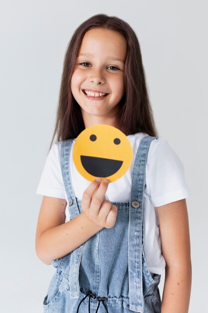 Medium shot girl holding emoji