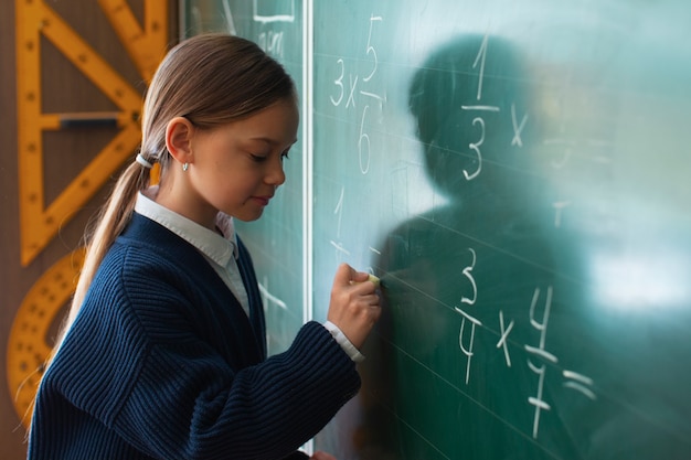 写真 学校で数学を学ぶミディアムショットの女の子