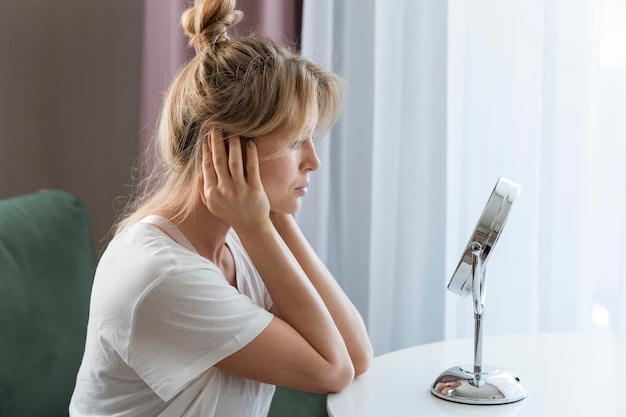 Colpo medio della ragazza guardarsi allo specchio