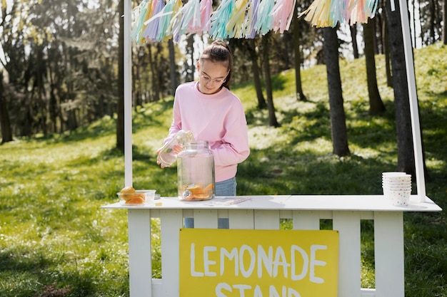 写真 屋外でレモネードを作るミディアムショットの女の子