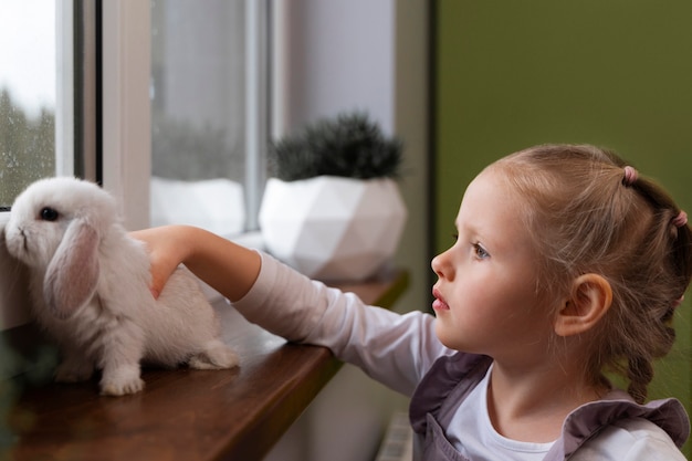 Medium shot girl playing with bunny