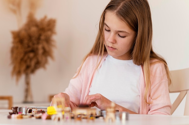 Medium shot girl playing with clay indoors