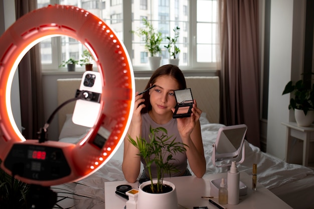 Medium shot girl recording her makeup routine