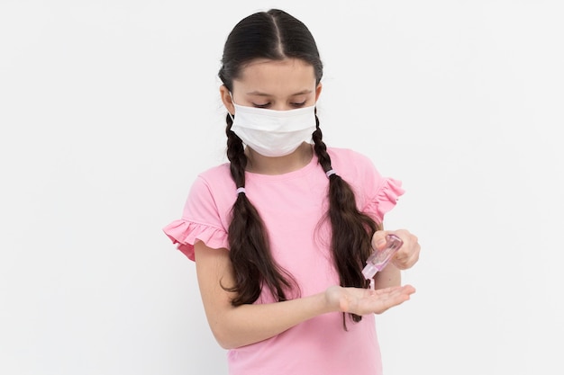 Foto ragazza del tiro medio che usando disinfettante