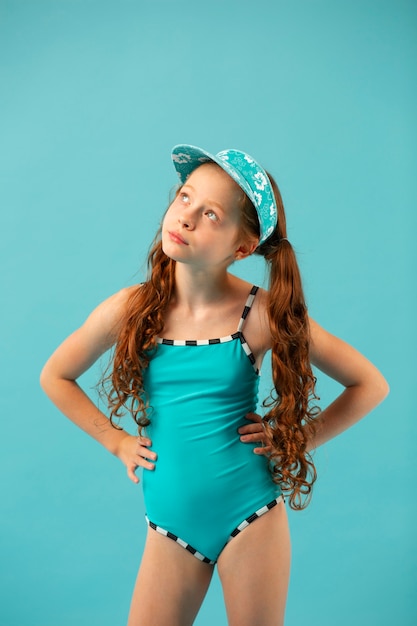 Foto ragazza del tiro medio che indossa un costume da bagno blu