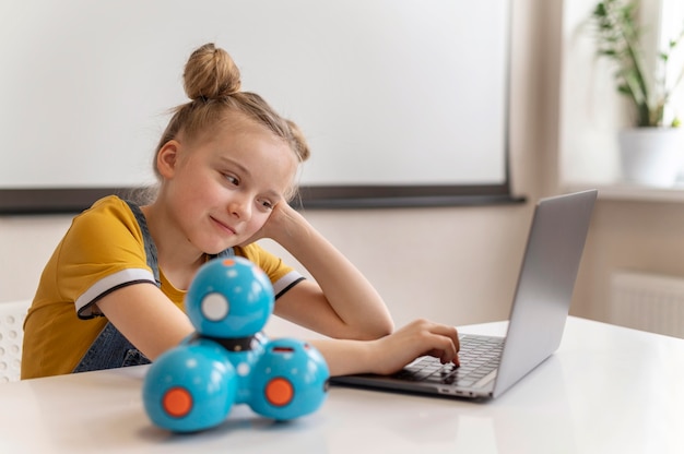 Foto ragazza del colpo medio con il computer portatile