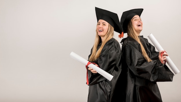 Medium shot graduates laughing with copy space