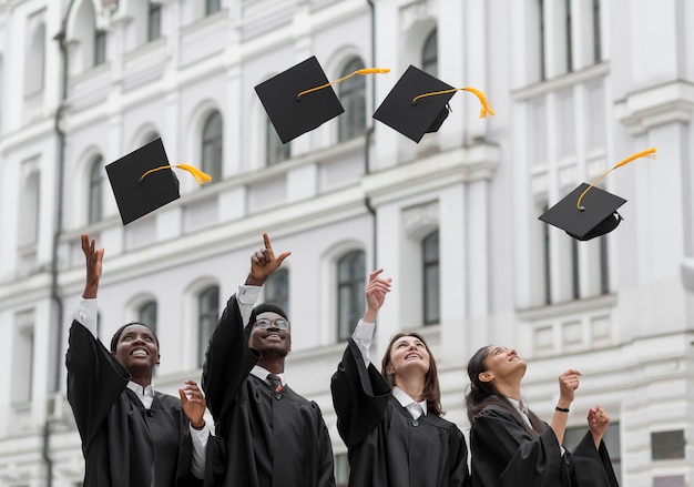 Medium shot graduates throwing caps up