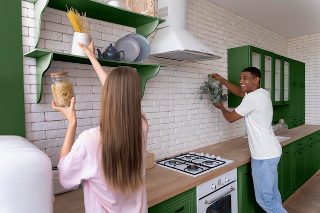 medium shot happy couple in green kitchen