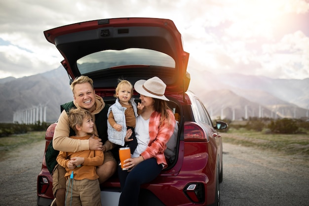 Famiglia felice del tiro medio con l'auto