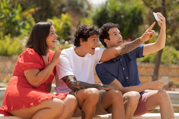 Amici felici del tiro medio che prendono selfie